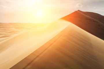 High sand dunes in the rays of evening sun