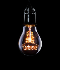 Hanging lightbulb with glowing Conference concept.