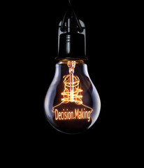 Hanging lightbulb with glowing Decision Making concept.