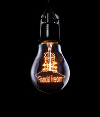 Hanging lightbulb with glowing Financial Freedom concept.