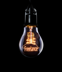 Hanging lightbulb with glowing Freelance concept.
