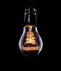 Hanging lightbulb with glowing Implement concept.