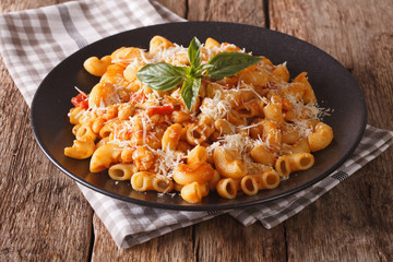 gomiti pasta with tomatoes, beans and parmesan on a plate close-up. Horizontal
