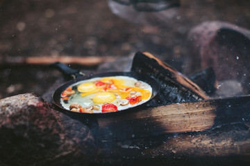 scrambled eggs with mushrooms and pepper on fire