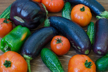 Vegetables stacked on a wooden table.