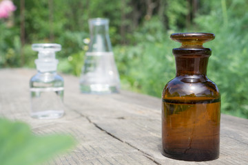 Liquid in chemical ware on a background of plants, fertilizers or pesticides in the garden.