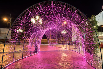 Arch tunnel walkway decorated with pink light illumination