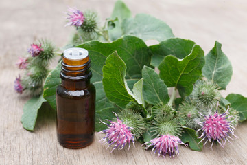 agrimony, burdock essential oil container with agrimony flowers