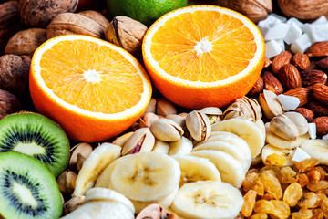 Fresh fruits. Healthy food. Mixed fruits and nuts background.Healthy eating, dieting, love fruits. Studio photography of different fruits and nuts on old wooden table. Organic Healthy Assorted Fruits.