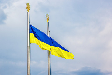 Flag of Ukraine fluttering in the wind against blue sky. Photo of blue and yellow national flag.