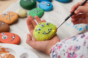 Child painting a stone monster craft