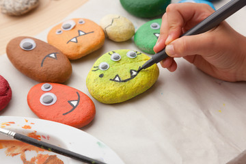Child painting a stone monster craft