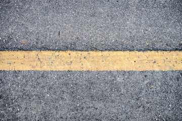 Fototapeta premium Yellow line on asphalt road texture