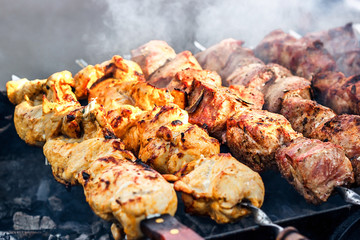 Grilling marinated shashlik preparing on a barbecue grill over charcoal. Shashlik is a form of Shish kebab popular in Eastern Europe. Shashlyk (meaning skewered meat) was originally made of lamb.
