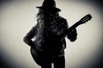 silhouette of funky beard man playing guitar