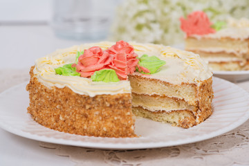 Creamy cake on plate on table on light background