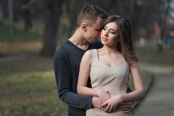 Naklejka premium Young, happy and attractive couple enjoying together in walk through the city park. Urban outdoors.