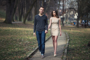 Obraz premium Young, happy and attractive couple enjoying together in walk through the city park. Urban outdoors.