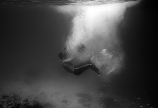 Fototapeta Diver plummet into black ocean with sunlight bubble,black and wh