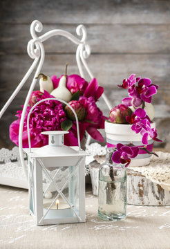 White lantern and floral arrangement with pink peonies and viole