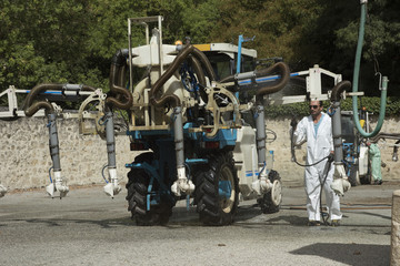 Washing down a tractor and spray pipes used to spray vines at Margaux in the Medoc region of France