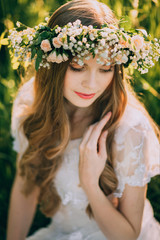 Beautiful young woman with wreath of wildflowers in their hair