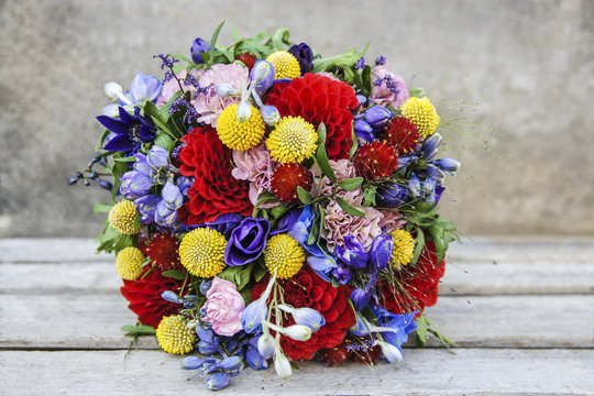 Wedding bouquet with red dahlias, pink carnations, yellow craspe