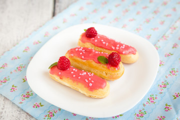 Eclair with cream and raspberry
