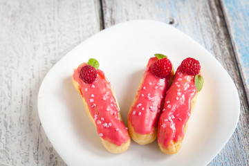 Eclair with cream and raspberry