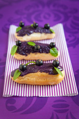 Eclair with cream and black currants