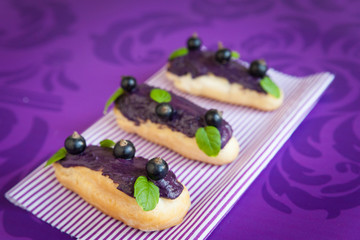 Eclair with cream and black currants