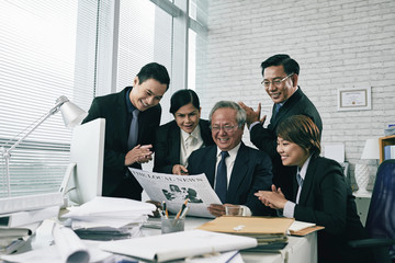 Happy team of lawyers reading article in newspaper