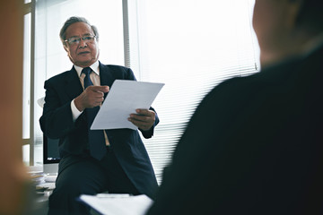 Senior Vietnamese lawyer consulting client in office