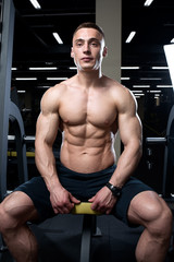 Fototapeta na wymiar Muscular topless man sitting topless in the gym