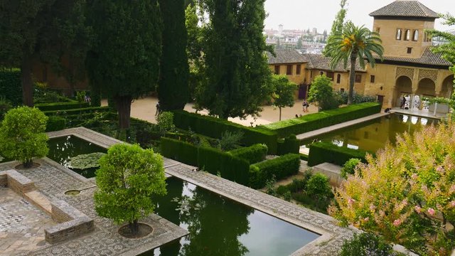 Granada, Andalusia, Spain - June 2016: Garden of fortress at Alhambra of Granada with pink flowers trees