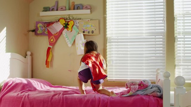 Young girl dressed as superheroes playing at home - 4K