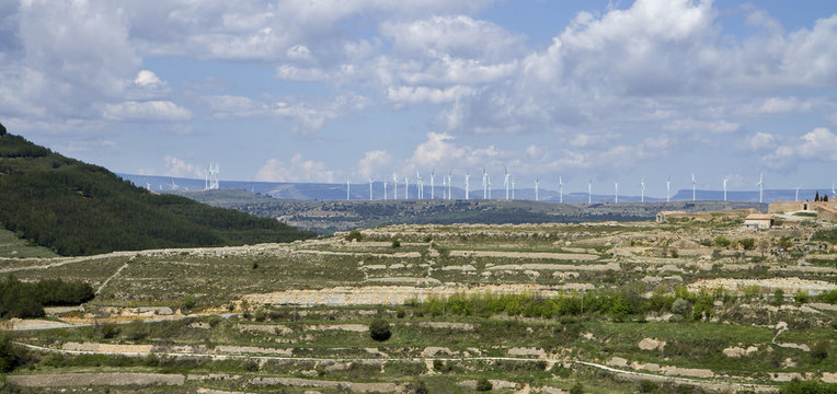 Utsikt &ouml;ver terrasserat landskap med vindkraftverk