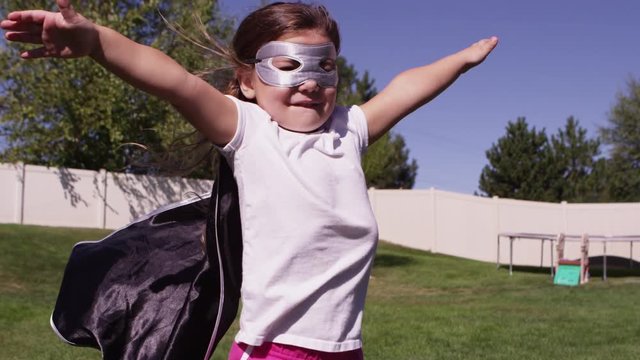Young girls dressed as superheroes playing outside - 4K