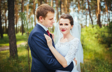 Bride and groom at wedding Day walking Outdoors on summer nature. Bridal couple, Happy Newlywed woman and man embracing. Loving wedding couple outdoor. Bride and groom