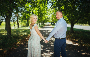 Bride and groom at wedding day, walking outdoor at summer on nature. Bridal couple, happy newlywed woman and man embracing. Loving wedding couple outdoor. 