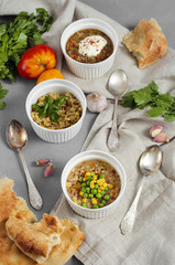 Three bowls of bean, quinoa soup and mushroom bulgur on a gray b