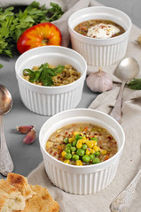 Three bowls of bean, quinoa soup and mushroom bulgur on a gray b