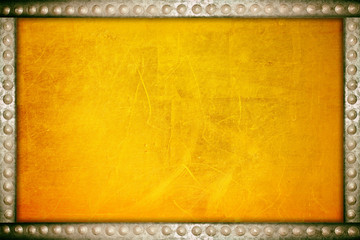 Scratches on a metallic gold background with metal rivets frame