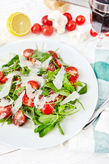 Fresh, summer salad with halves of cherry tomatoes and arugula