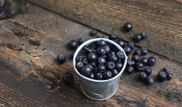 Ripe blueberries in a cup on rustic wooden table