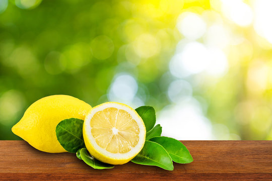 Lemons with leaves on wooden background. fresh lemons on natural background.