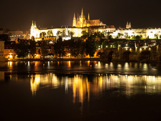 Fototapeta na wymiar Night Prague Castle with St Vitus Cathedral and Charles Bridge reflected in Vltava river, Prague, Czech Republic