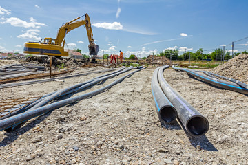Front view on long black water HDPE pipe with blue stripe at con