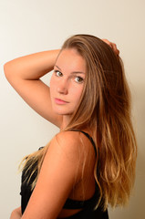 Naklejka premium junge Frau mit romantischem Blick greift sich ins lange Haar