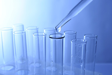 Close up of a pipette dropping sample into a test tube